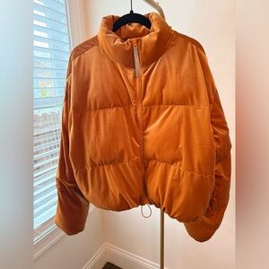 Fabletics Wander velour cropped puffer jacket in rust orange.